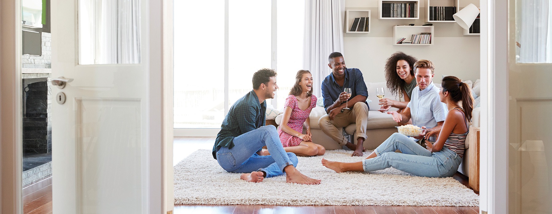 lifestyle image of a group of people laughing and socializing on a living area floor